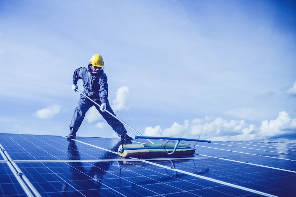 man cleaning solar panels